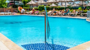 A swimming pool with lounge chairs and umbrellas. - Sunday Hotel (Rhodes)