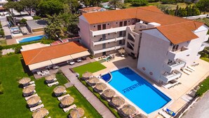 A hotel with a swimming pool, multiple balconies, and a rooftop terrace. - Sunday Hotel (Rhodes)