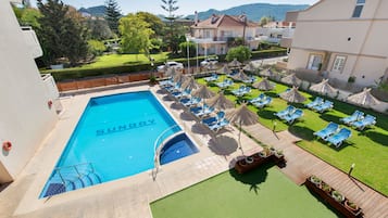 Alberca al aire libre por temporada y sombrillas en la alberca