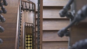 A staircase with a metal handrail and a yellow and black checkered floor. - The Hat Madrid (Madrid)