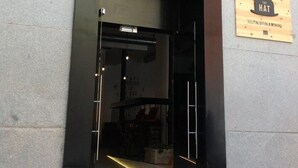 A hotel entrance with a sign reading "The Hat" indicating it is a place for sleeping, eating, and drinking. - The Hat Madrid (Madrid)