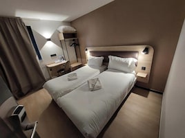 Una habitación de hotel con cama doble, un escritorio y una silla.