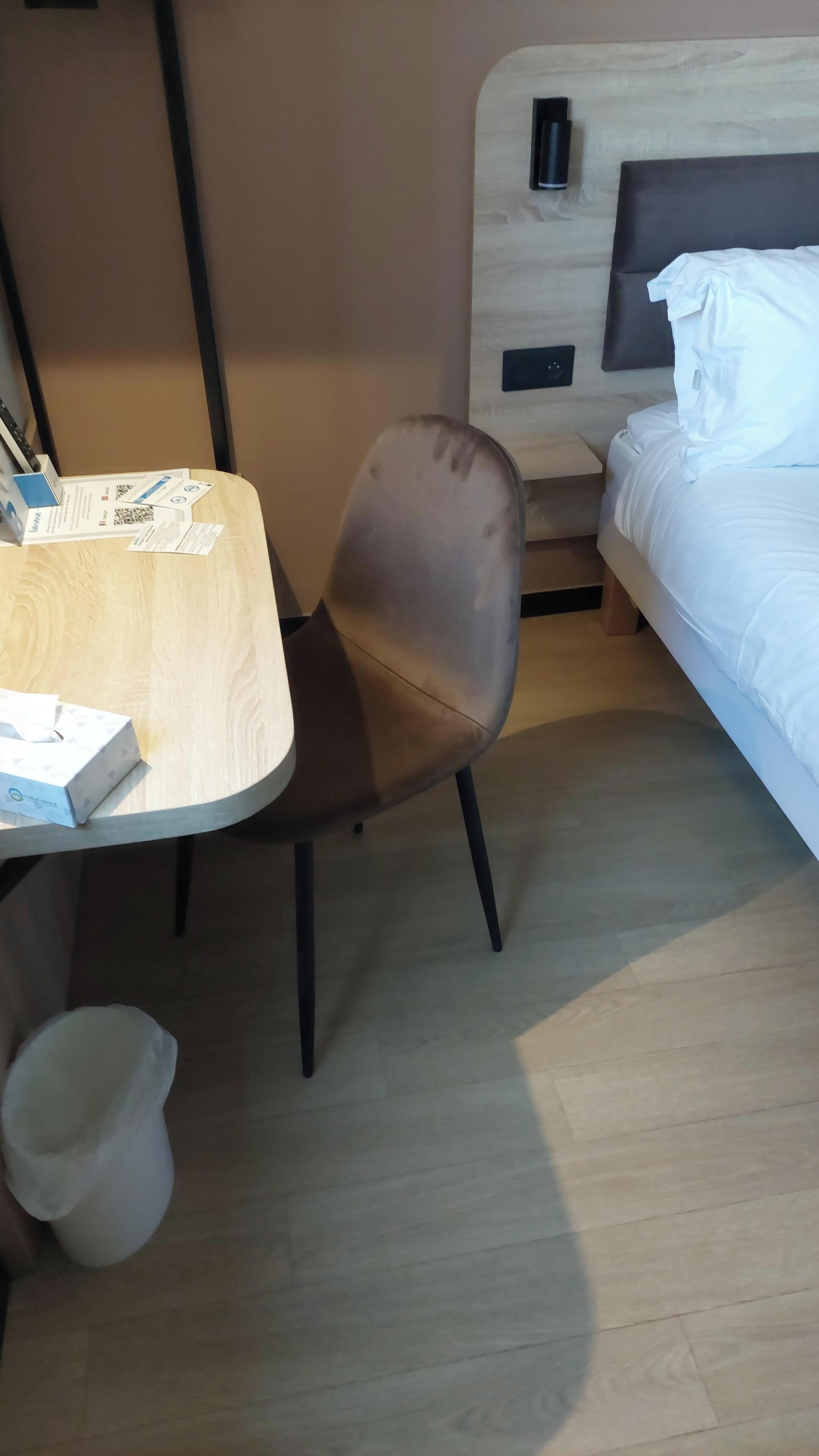 A compact room with a bed, a table, and a chair.