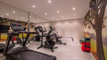 A modern gym with treadmills, stationary bikes, and ellipticals.