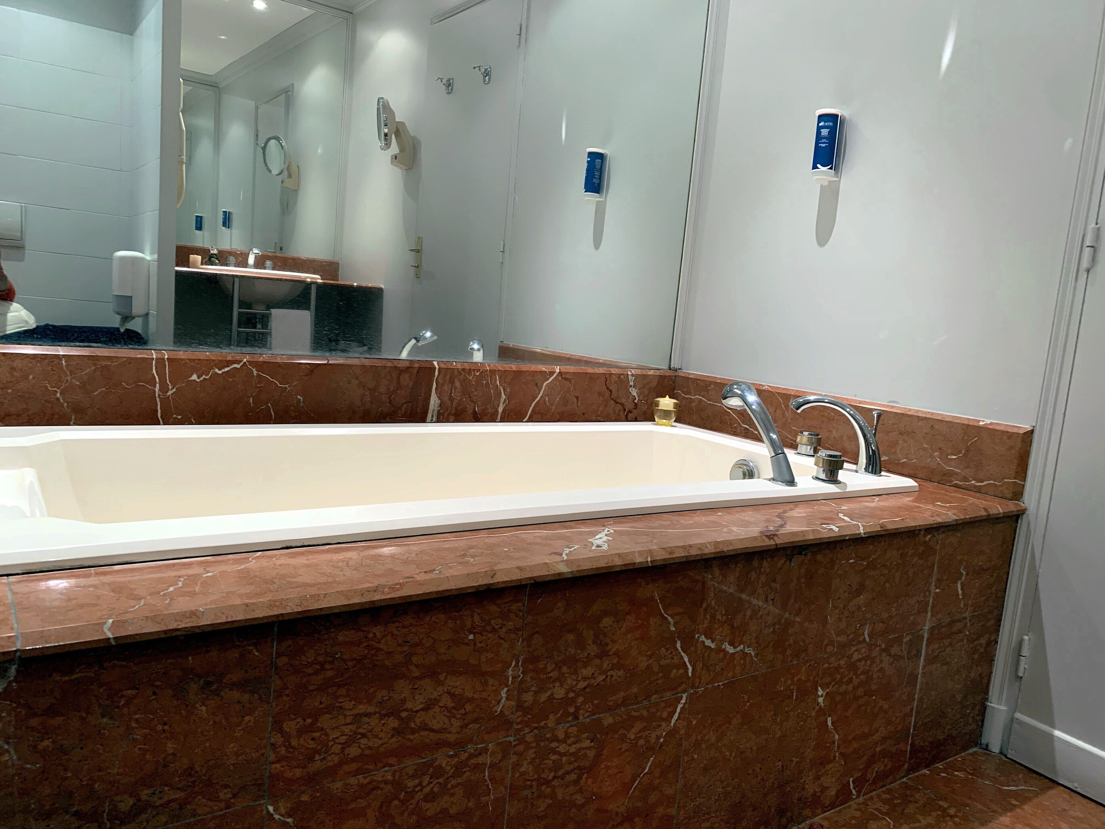 Un baño moderno con una bañera grande, un tocador con espejo y zona de ducha.