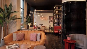 Un espace détente moderne avec des canapés en cuir, une table basse et une petite table d’appoint rouge.
