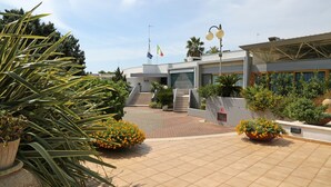 A modern building with a tiled entrance, a staircase, and potted plants. - Hotel Santa Lucia (Santa Cesarea Terme)