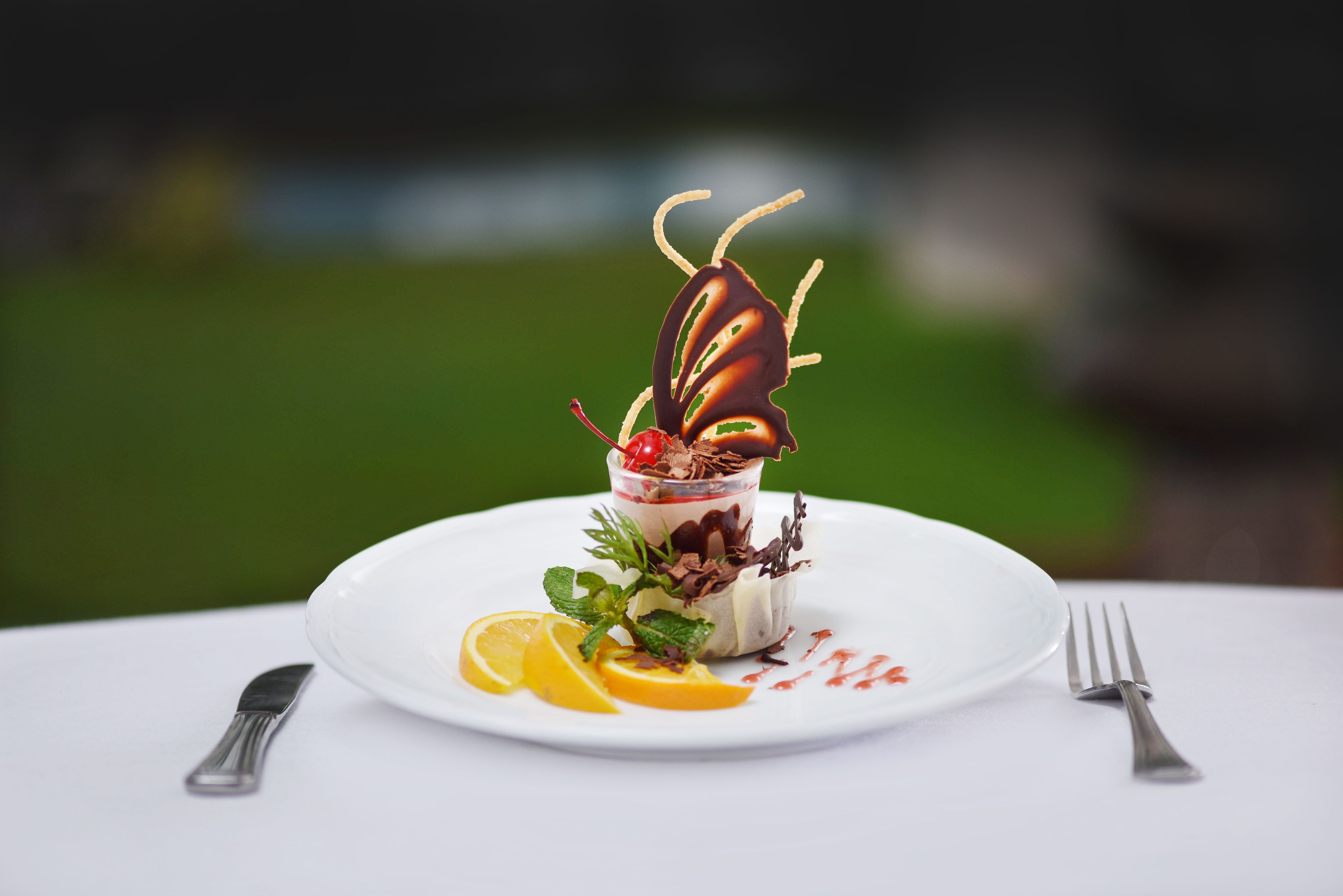 Un postre en un plato blanco con un tenedor y un cuchillo a un lado.