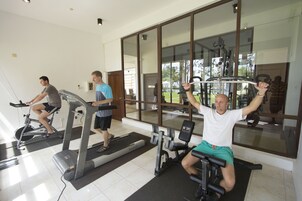 Un gimnasio con cintas de correr, bicicletas estáticas y máquinas de pesas.
