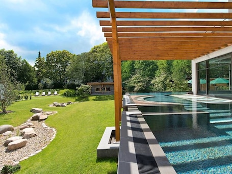 Una piscina cubierta, una piscina al aire libre, sombrillas, tumbonas