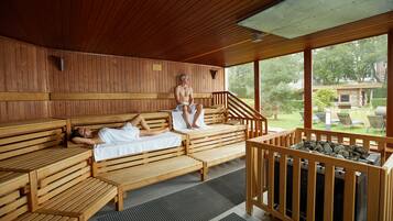 Una sauna con bancos de madera y una zona de hidromasaje de piedra.