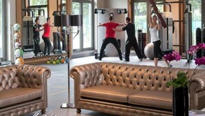 Une salle de sport équipée de matériel d’exercice, dotée d’un miroir et de grandes fenêtres.