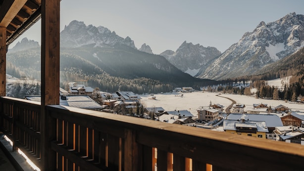 Un borgo montano con case in legno e un paesaggio innevato.