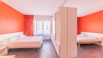Une chambre d’hôtel avec deux lits, une armoire et une fenêtre avec des rideaux.