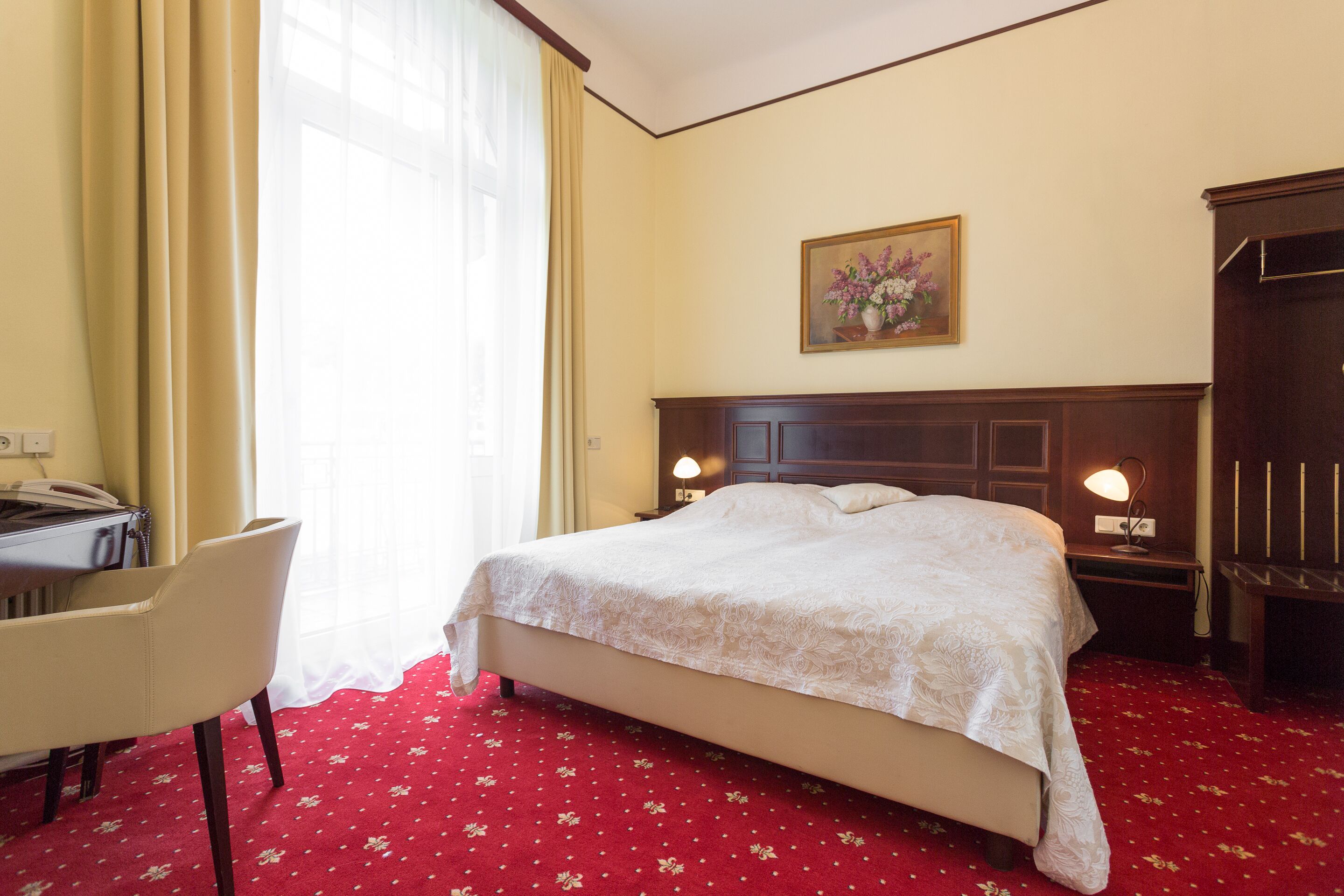 Une chambre d’hôtel avec un lit, un bureau et une chaise.
