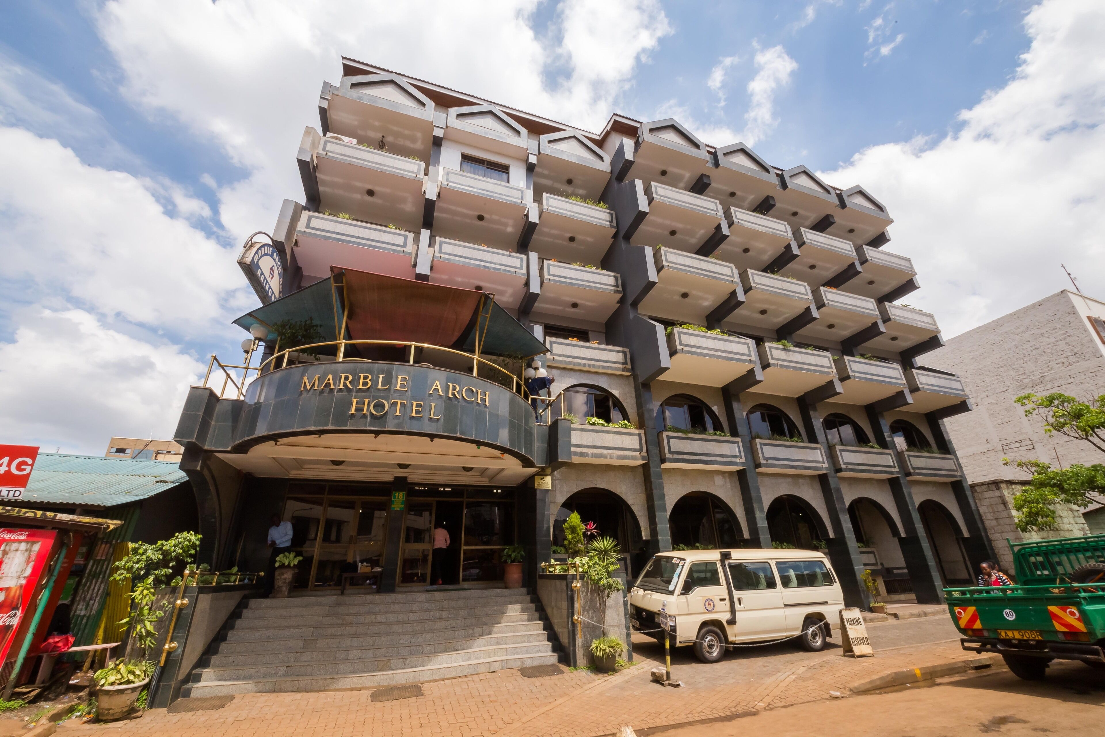 Hotel com design arquitetônico único, apresentando várias sacadas e uma entrada curva.