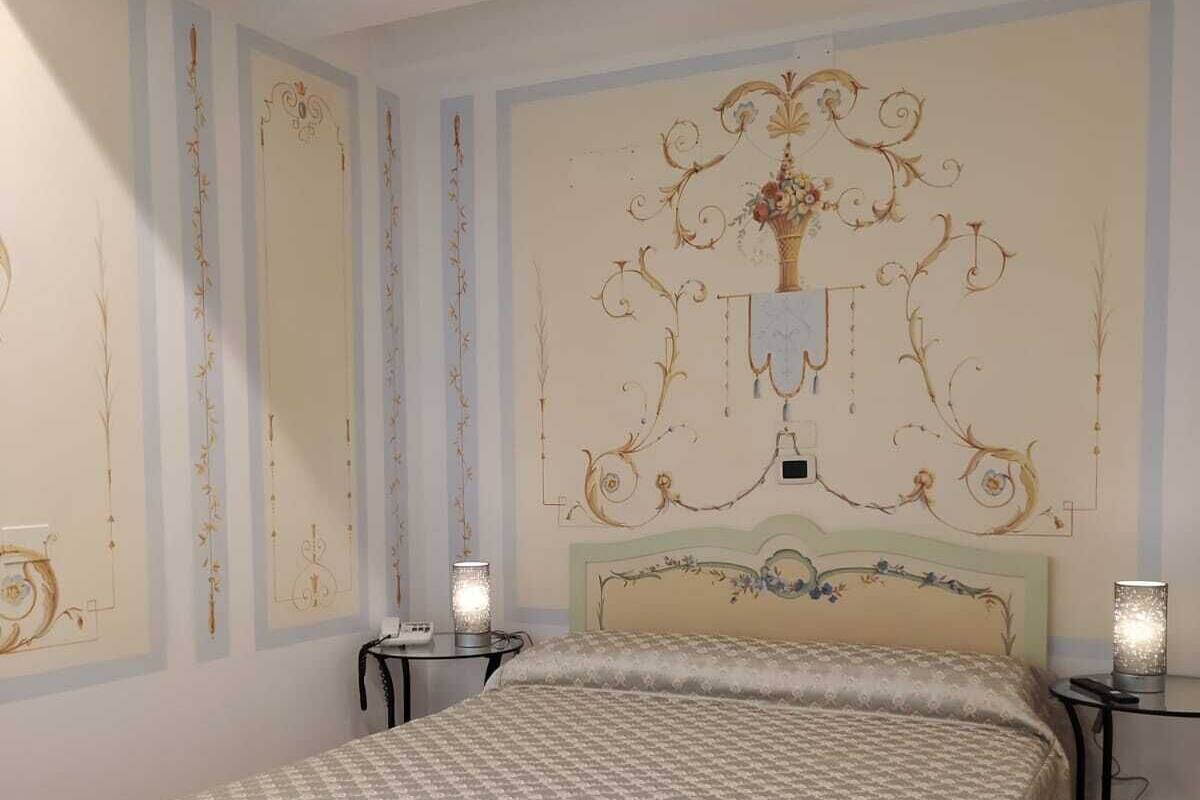 A bedroom with a large bed, two bedside tables, and a decorative wall panel.