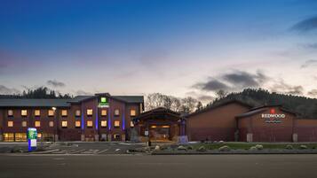 A Holiday Inn Express building with a brick facade, a separate Redwood Hotel Casino building, and a well-maintained parking lot.