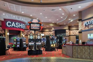 A casino floor with multiple slot machines, a cashier area, and a sign indicating a current jackpot. - Holiday Inn Express Klamath - Redwood Ntl Pk Area by IHG (Klamath)
