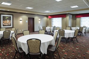 A conference room with round tables, chairs, and a large framed picture on the wall. - Holiday Inn Express Klamath - Redwood Ntl Pk Area by IHG (Klamath)