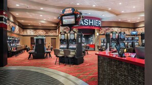 A casino floor with multiple slot machines, a cashier counter, and a red carpeted area. - Holiday Inn Express Klamath - Redwood Ntl Pk Area by IHG (Klamath)