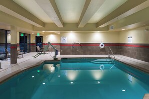 A swimming pool with a lifeguard chair, a pool lift, and a sign indicating a depth of 3 feet 11 inches. - Holiday Inn Express Klamath - Redwood Ntl Pk Area by IHG (Klamath)
