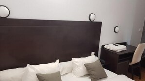 Una habitación de hotel con una cama grande, un escritorio y una silla.