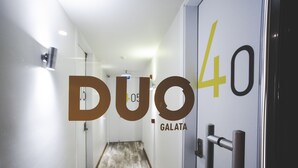 Un pasillo con piso de madera, una puerta con el número 40 y la inscripción "Duo 40 GALATA".