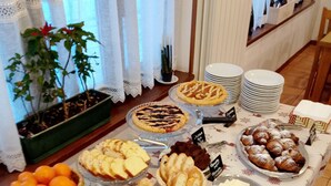 A buffet table with various food items and a potted plant.