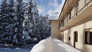 A snow-covered courtyard with a building featuring balconies and windows.