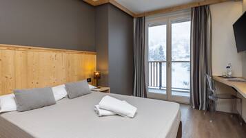 Camera singola | Una cassaforte in camera, una scrivania, lenzuola