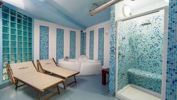 Bathroom features a large bathtub and shower area, with blue mosaic tiles and a large window.