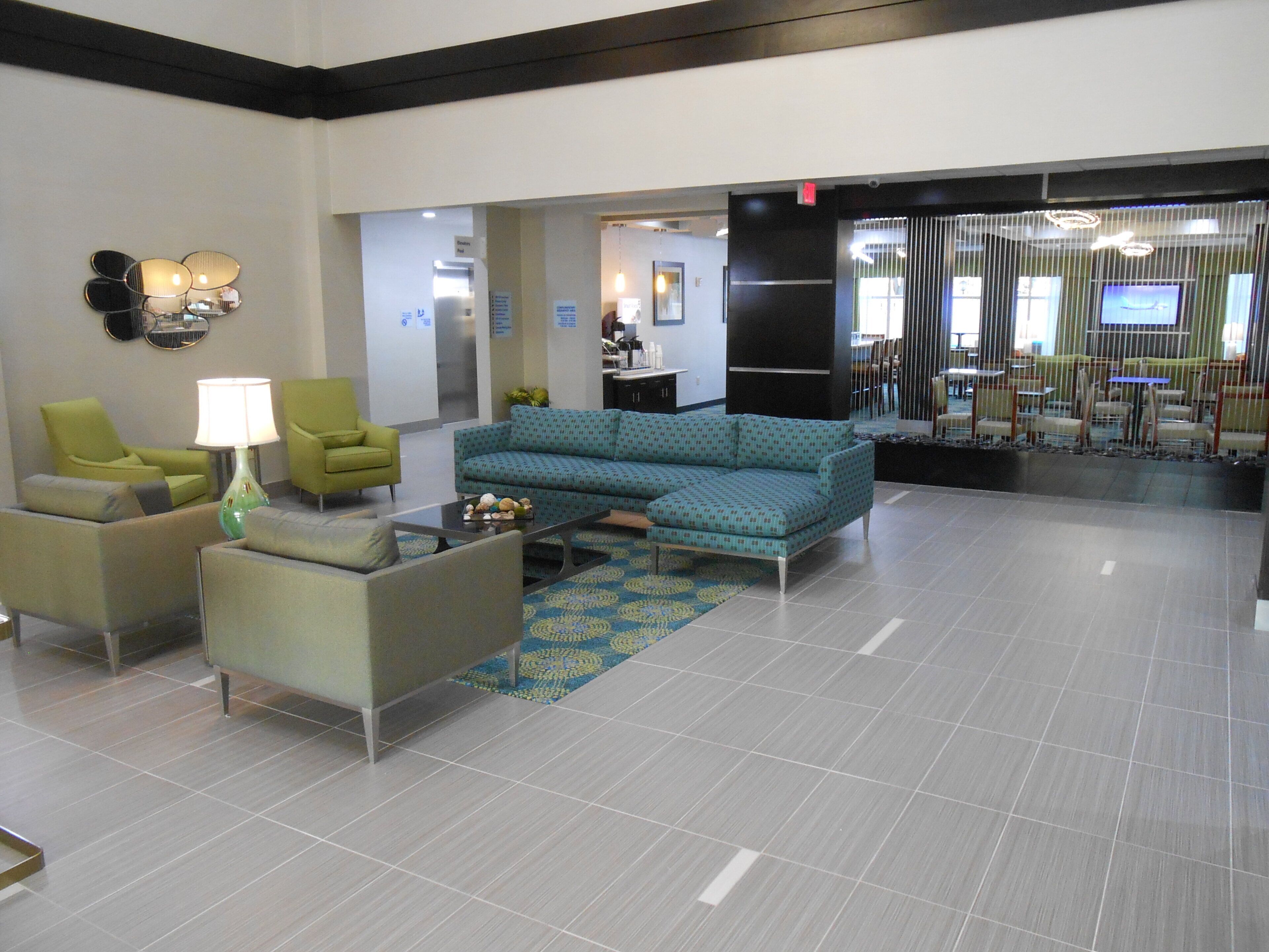 A lobby with seating, a coffee table, and a patterned rug.