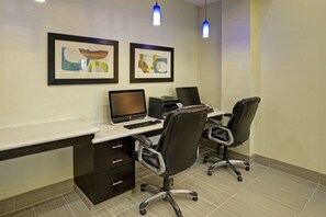 A modern office space with a desk, two chairs, a printer, and framed artwork on the wall. - Holiday Inn Express Hotel & Suites Houston NW-Brookhollow by IHG (Houston)