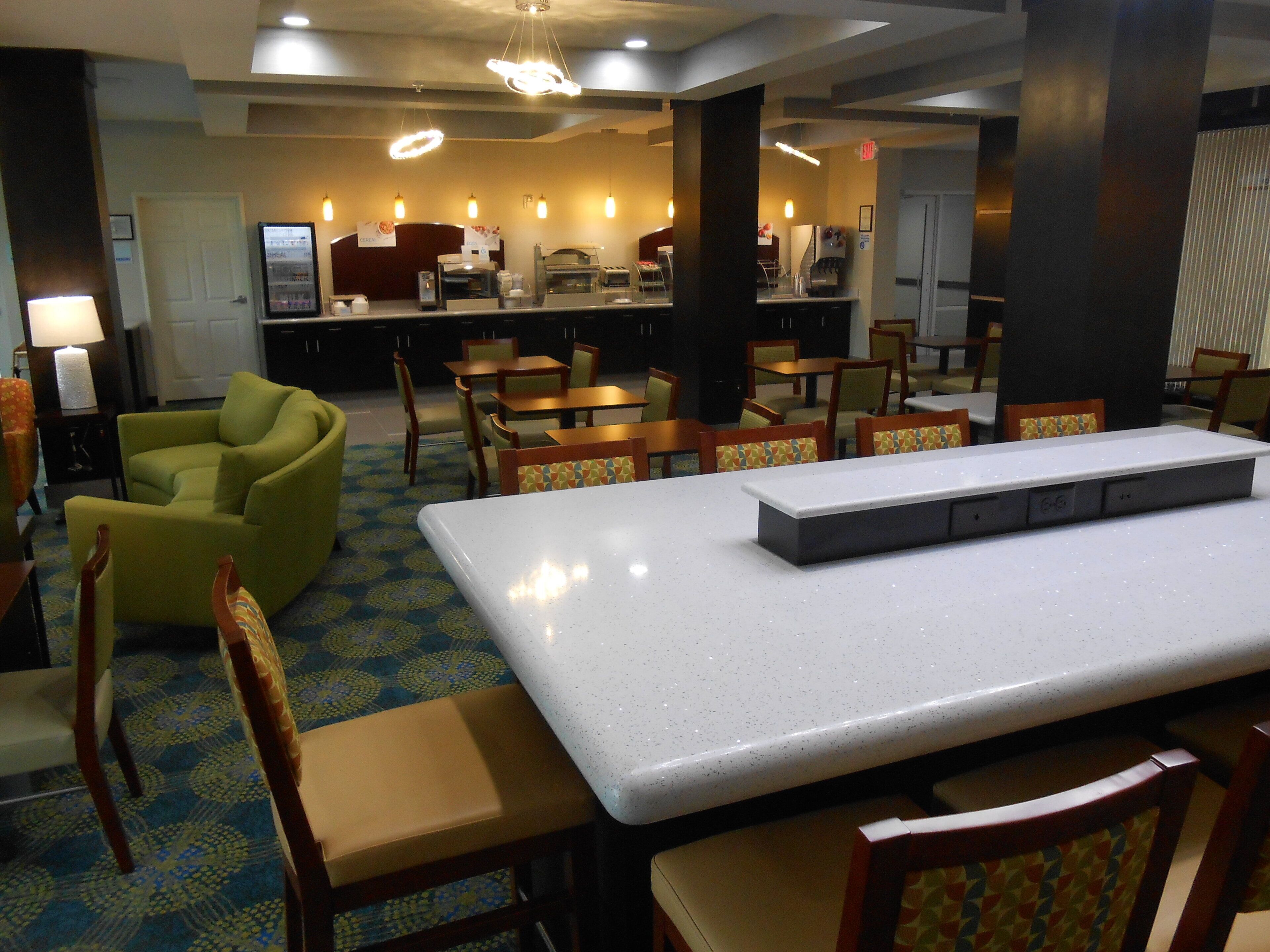 Un comedor de hotel con una larga mesa, sillas y una máquina de café.
