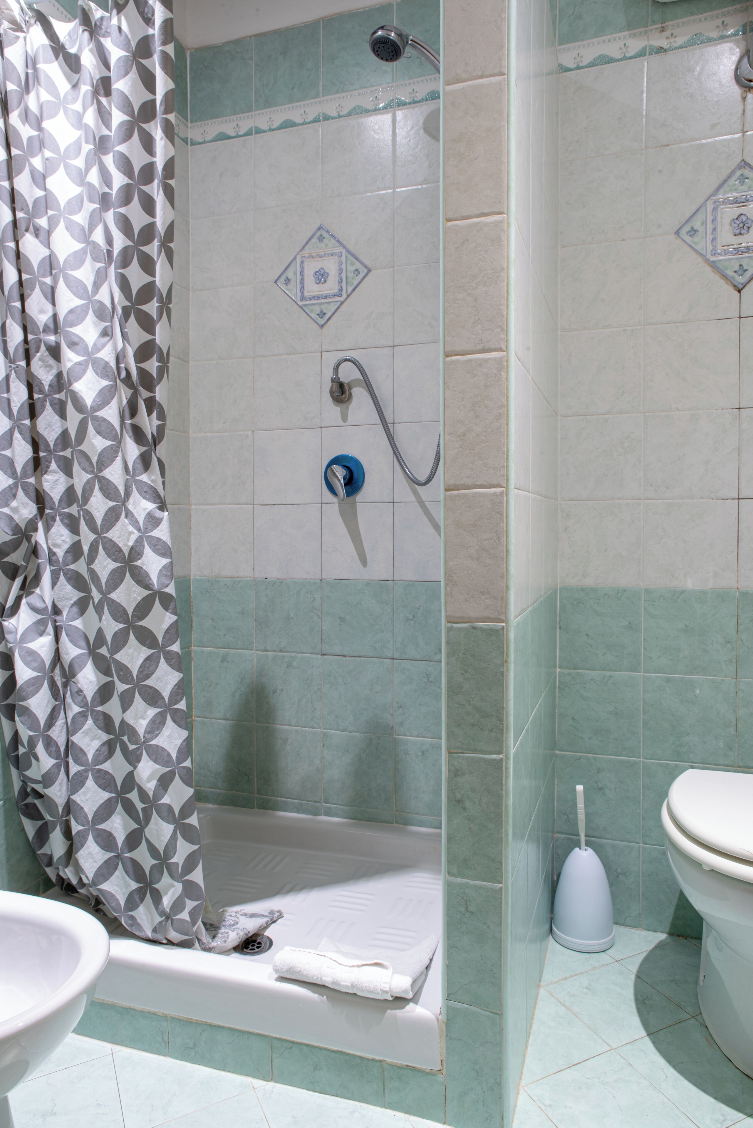 A bathroom with a shower, toilet, and sink.