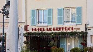 A hotel with a balcony, outdoor seating, and potted plants. - Hotel le Beffroi (Dreux)