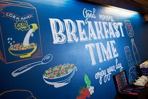 Pared con temática de desayuno, que incluye ilustraciones de cereales y café.