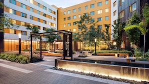 Une cour d’hôtel agrémentée d’un élément aquatique, de coins salon et d’un panneau indiquant l’emplacement du « Residence Inn ».