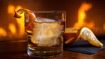 Un verre de boisson glacée, garni d’une tranche de citron, posé sur une table en bois.