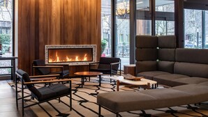 Un espace de détente moderne avec une cheminée, des sièges confortables et un tapis à motifs.