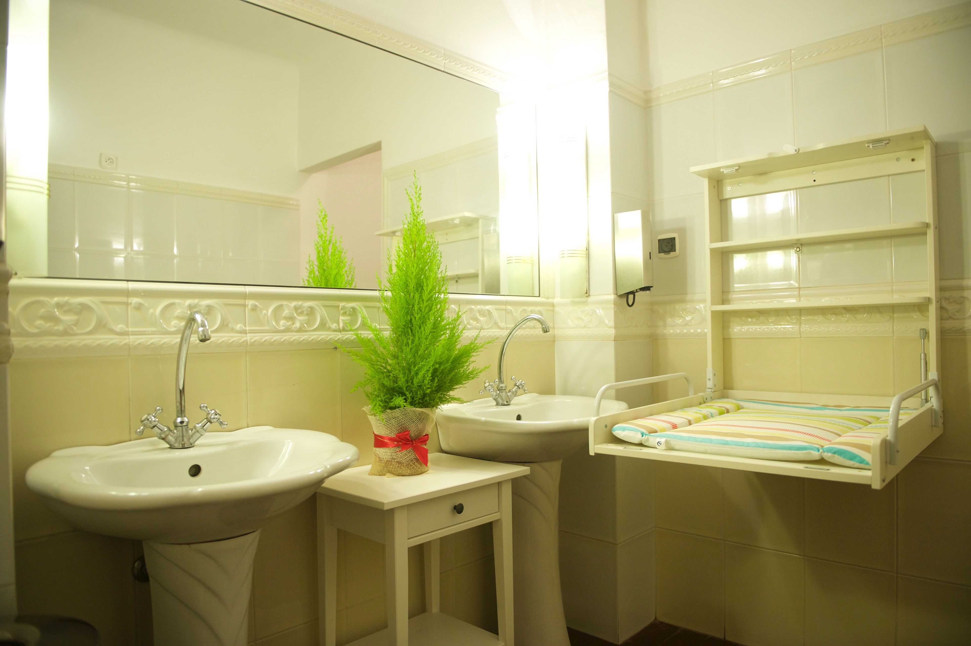 Un bagno con due lavabi, uno specchio e uno scaffale con articoli da toilette.