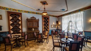 A room with a checkered wooden floor, wooden furniture, and a wine rack. - Małopolanka & Spa (Krynica-Zdroj)