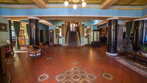 A grand lobby with a central staircase, large columns, and a patterned floor. - Małopolanka & Spa (Krynica-Zdroj)