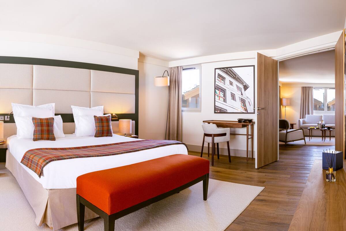 Een moderne hotelkamer met een groot bed, een bureau en een zithoek.