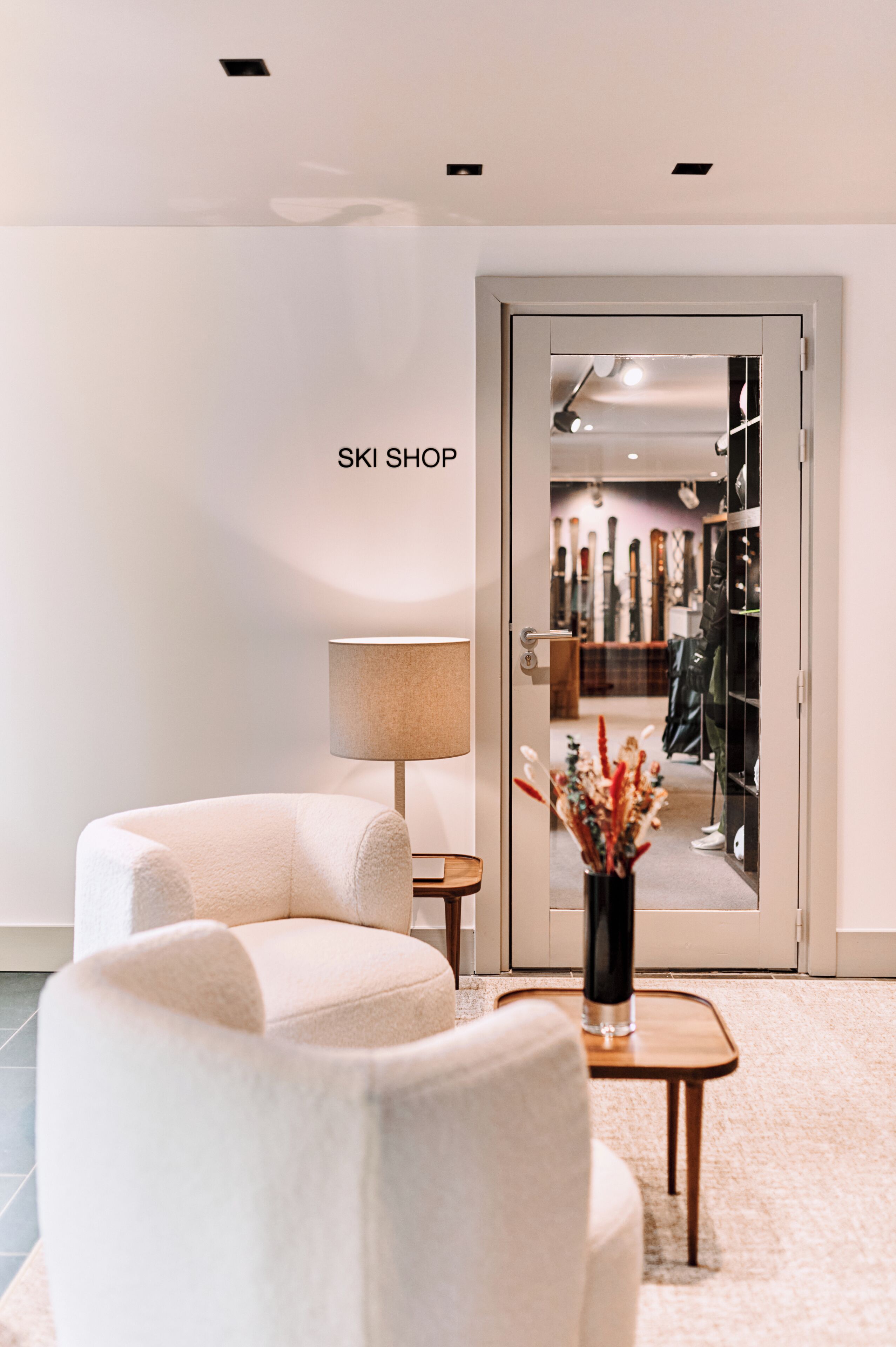 A modern interior with a sofa, a lamp, and a door labeled 'SKI SHOP'.