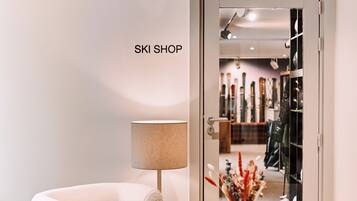 A modern interior with a sofa, a lamp, and a door labeled 'SKI SHOP'.