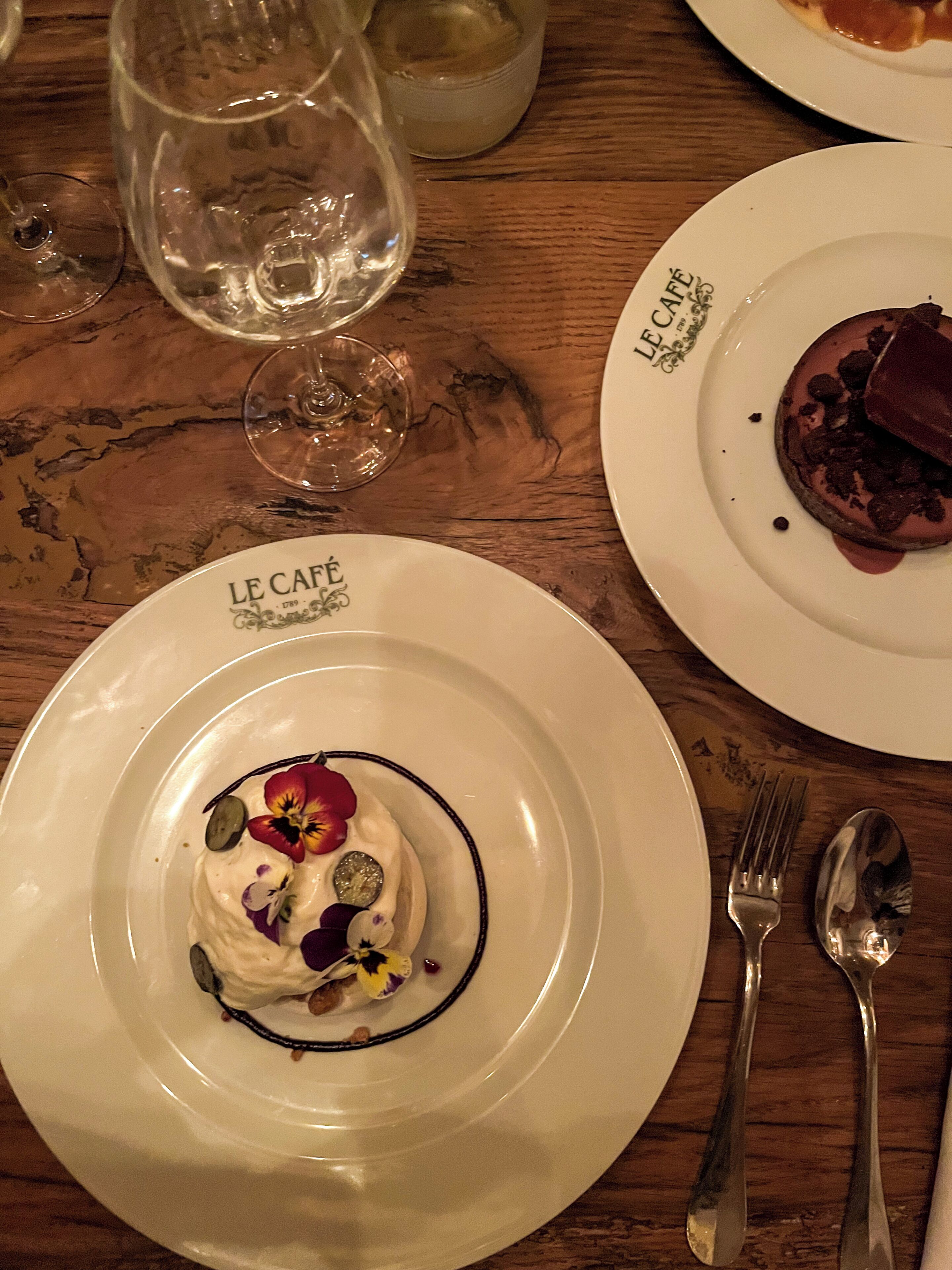 A dining table with plates, a glass, and cutlery.