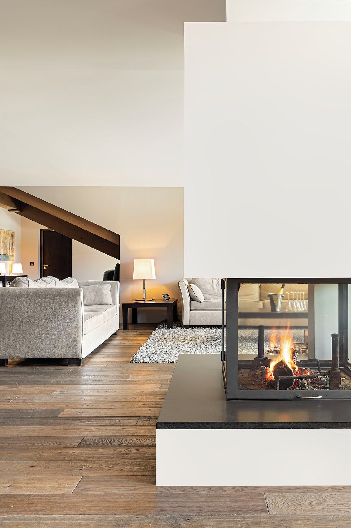 Una sala de estar moderna con chimenea, dos sofás, una mesa de centro y una alfombra.