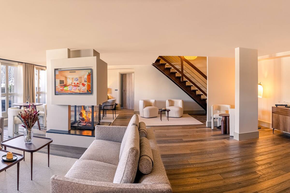 Een moderne woonkamer met een open haard, een bank en een koffiebar.